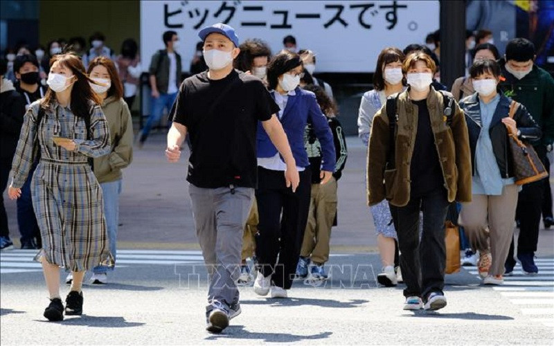 Người dân đeo khẩu trang phòng dịch COVID-19 tại Tokyo, Nhật Bản ngày 18/4/2021. Ảnh: AFP/TTXVN