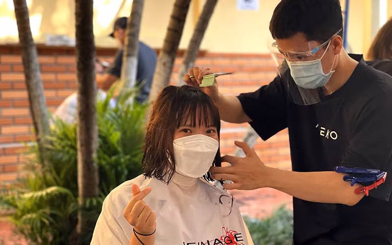 Nhóm thiện nguyện cắt tóc miễn phí cho các y, bác sĩ Bệnh viện Hữu nghị Việt Ðức trước ngày lên đường vào Trung tâm Hồi sức tích cực Covid-19 ở TP Hồ Chí Minh. Ảnh: CTV