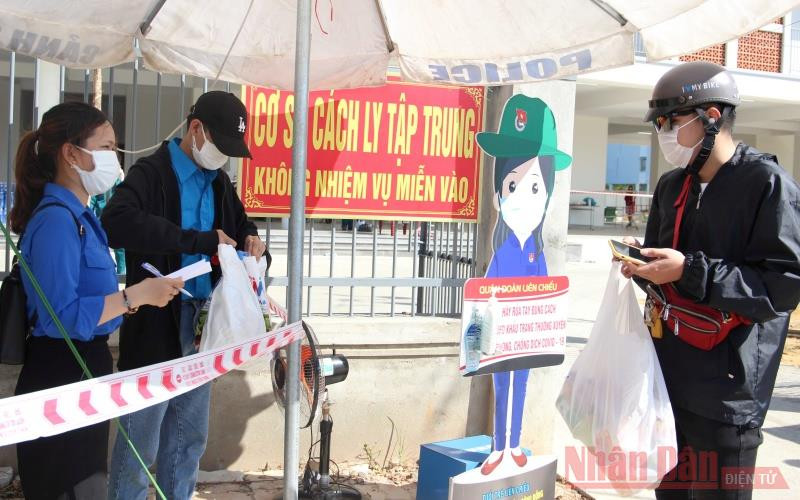 Tường Vỹ (bìa trái) ghi thông tin tiếp nhận đồ cho người cách ly.