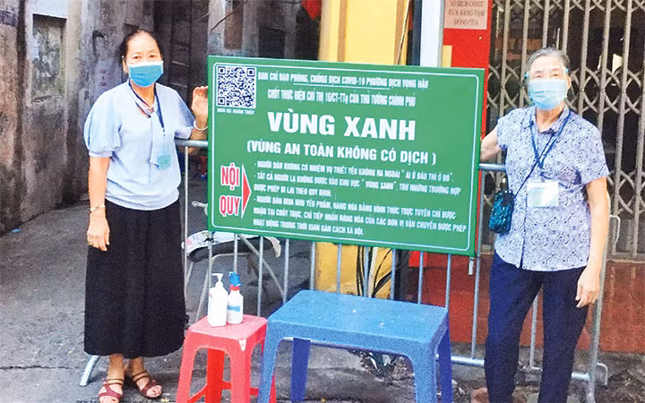 Bà Đỗ Thị Thảo (bên trái) tham gia trực chốt “vùng xanh” tại địa phương.