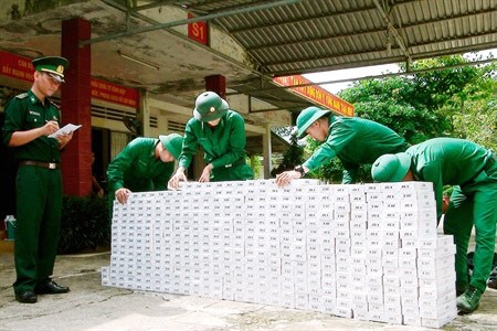 Cán bộ, chiến sĩ Ðồn Biên phòng Cửa khẩu quốc tế Bình Hiệp (tỉnh Long An) kiểm đếm tang vật vụ buôn lậu thuốc lá. Ảnh: MINH LUẬN 