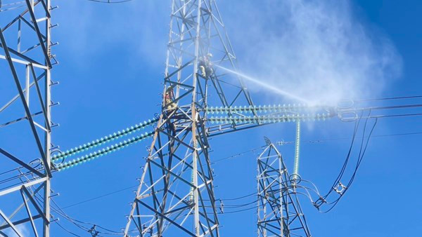 Công nhân Công ty Truyền tải điện 3 vệ sinh sứ hotline trên đường dây đang mang điện.