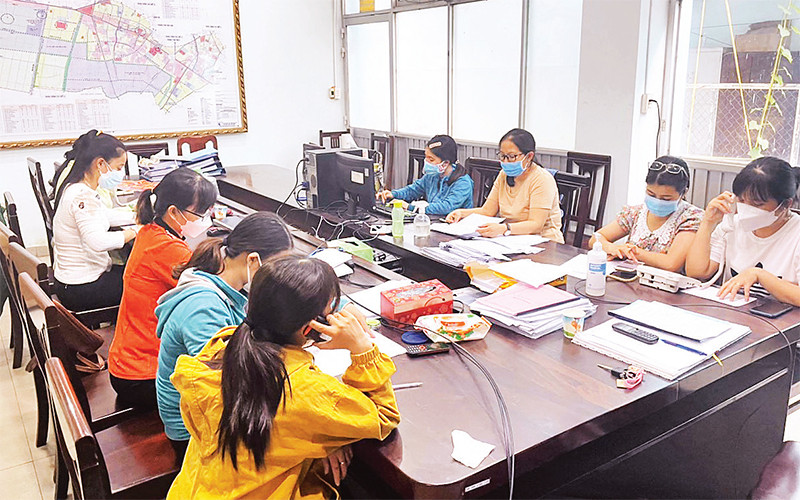 Nhân viên tư vấn, hỗ trợ F0 gọi điện thăm hỏi người bệnh từ Trung tâm Chỉ huy phòng, chống dịch Covid-19 xã Xuân Thới Thượng, huyện Hóc Môn. 