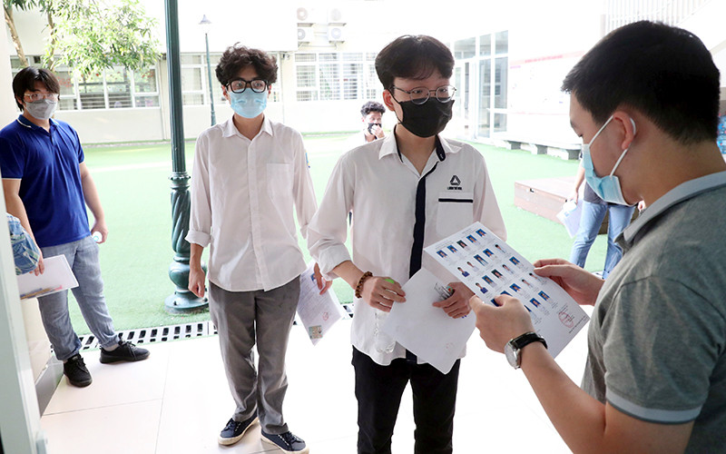 Giám thị kiểm tra thông tin thí sinh dự kỳ thi THPT quốc gia năm 2021 tại điểm thi Trường THCS Nghĩa Tân (Hà Nội). (Ảnh DUY ĐĂNG)