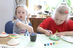 Các “nghệ nhân nhí” say sưa tô vẽ những chiếc nón lá Việt Nam.