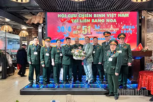 Chủ tịch Liên hiệp các tổ chức người Việt Nam tại Liên bang Nga Đỗ Xuân Hoàng tặng hoa chúc mừng Hội Cựu chiến binh Việt Nam tại Liên bang Nga. (Ảnh: XUÂN HƯNG)