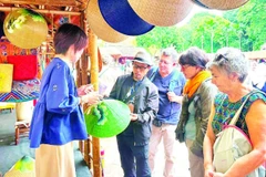 Khách quốc tế tìm hiểu sản phẩm thủ công mỹ nghệ tại Festival Thăng Long-Hà Nội.