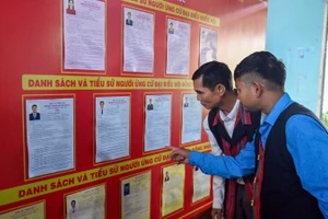 Cử tri xã A Lưới 1 tìm hiểu các ứng cử viên qua bản niêm yết.