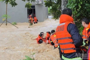 Lực lượng công an xã Đồng Kỳ (Bắc Ninh) cứu gia đình 5 người bị lũ cô lập. (Ảnh: ĐẶNG GIANG)