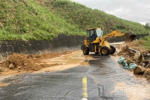 Công nhân túc trực dọn đất đá theo mưa lũ chảy xuống mặt đường để bảo đảm an toàn giao thông.