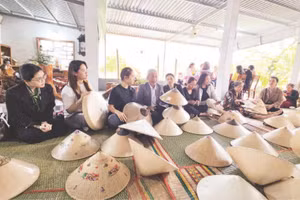 Du khách tìm hiểu các công đoạn chế tác nón ngựa tại cơ sở của Nghệ nhân Ưu tú Đỗ Văn Lan.