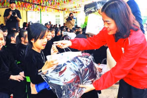 Lãnh đạo Hội Chữ thập đỏ trao quà cho các học sinh trên địa bàn. (Ảnh LƯƠNG THẢO)