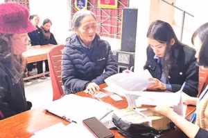 Cán bộ xã Tuyên Sơn, tỉnh Quảng Trị chi trả tiền quà Tết, tặng người dân.