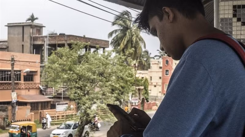 Người dân sử dụng điện thoại di động ở Kolkata, Ấn Độ. (Ảnh minh họa: Xinhua)