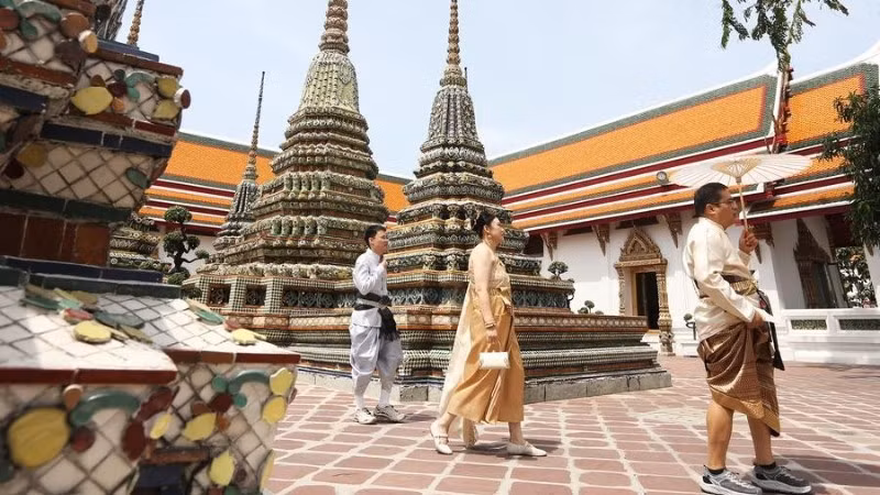 Khách du lịch trong trang phục truyền thống của Thái Lan tham quan chùa Wat Pho ở Bangkok. (Ảnh minh họa: Tân Hoa xã)