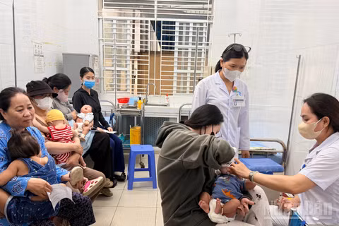 Phụ huynh đưa trẻ đi tiêm chủng tại Trạm y tế phường Phan Thiết.