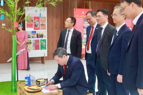 Giáo sư, Tiến sĩ Lê Văn Lợi, Chủ tịch Viện Hàn lâm Khoa học xã hội Việt Nam viết lời chúc năm mới tại không gian trưng bày cây Nêu – biểu tượng truyền thống của dân tộc Việt Nam về một năm mới an lành.