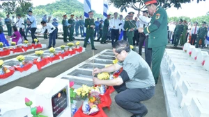 Thủ tướng Chính phủ Phạm Minh Chính thắp hương tại các phần mộ liệt sĩ mới an táng tại buổi lễ. (Ảnh: THANH GIANG) 