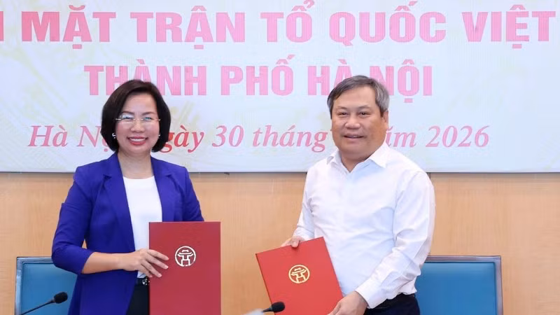 Chủ tịch Ủy ban nhân dân thành phố Hà Nội Vũ Đại Thắng trao biên bản bàn giao 18 hội cho Chủ tịch Ủy ban Mặt trận Tổ quốc Việt Nam thành phố Bùi Huyền Mai. (Ảnh: ĐÌNH HIỆP)