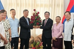 Đại sứ Lê Quang Long tặng hoa chúc mừng Đại sứ Vanhtha Sengmeuang và toàn thể cán bộ nhân viên Đại sứ quán Lào. (Ảnh: Đại sứ quán Việt Nam tại Cuba)