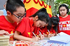 Các cháu thiếu nhi tham gia viết thư tay tại không gian triển lãm “Viết thư cho Tổ quốc”.