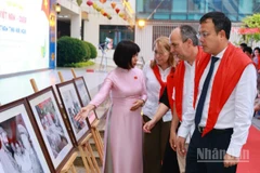 Hiệu trưởng Trường tiểu học Việt Nam-Cuba Trần Thị Tố Trinh giới thiệu với Đại sứ Cuba tại Việt Nam Rogelio Polanco Fuentes và các đại biểu về các tác phẩm tranh ảnh trưng bày tại Triển lãm.