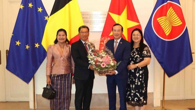 Đại sứ Kingphokeo Phommahaxay (trái) tặng hoa cho Đại sứ Nguyễn Văn Thảo. (Ảnh: HƯƠNG GIANG/TTXVN)