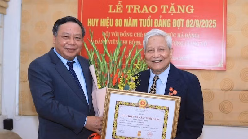 Đồng chí Nguyễn Văn Phong, Phó Bí thư Thường trực Thành ủy Hà Nội trao tặng Huy hiệu 80 năm tuổi Đảng cho nhà báo Hà Đăng. (Ảnh: Quang Thái)