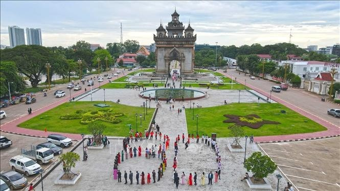 Cộng đồng người Việt cùng nhau xếp hình số "80" để chào mừng 80 năm Quốc khánh Việt Nam. (Ảnh: Đỗ Bá Thành/PV TTXVN tại Lào)