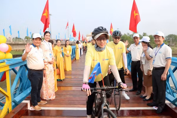 Các vận động viên đạp xe diễu hành qua cầu Hiền Lương.
