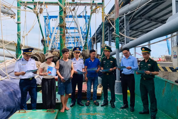 Các đơn vị tuyên truyền, phát tờ rơi trên các tàu cá đang neo đậu tại Cảng Nam Cửa Việt. (Ảnh: XUÂN THẾ).
