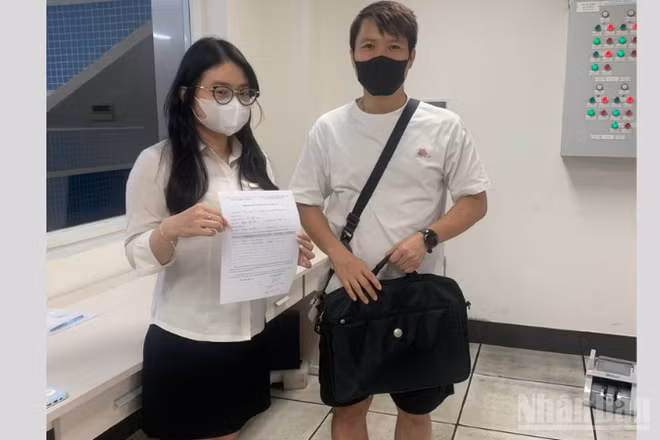 Hành khách Nguyễn Văn Hiếu (cầm cặp sách) nhận lại tài sản bỏ quên từ Hà Nội Metro.