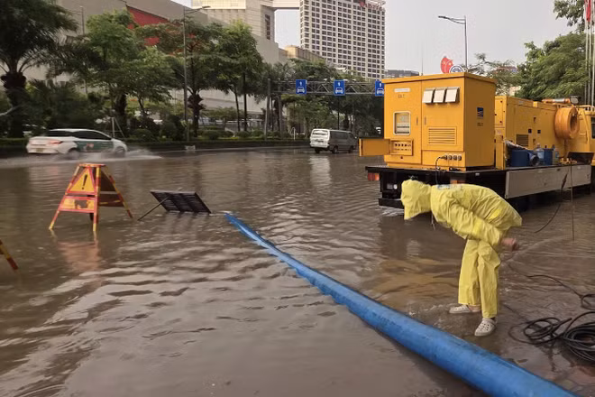 Nhân viên Công ty Thoát nước Hà Nội ứng trực tại điểm "dềnh nước" trên đường Võ Chí Công. (Nguồn: TTXVN)