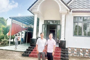 Nông dân Trần Quốc Thống (bên trái) trồng lúa ST 25 kết hợp nuôi tôm, mỗi năm thu lãi hơn một tỷ đồng, vừa xây nhà mới khang trang.