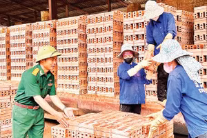 Cựu chiến binh Lưu Công Ruyên (bên trái) nỗ lực vươn lên tạo dựng mô hình phát triển kinh tế cho gia đình và duy trì việc làm thường xuyên lao động là con em hội viên cựu chiến binh, nhân dân địa phương. 