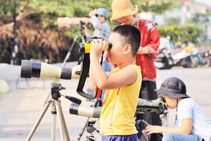 Các em nhỏ trải nghiệm ống nhòm chuyên dụng.