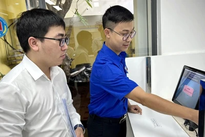 Cán bộ Trung tâm Đăng ký giao dịch, tài sản (thuộc Cục Đăng ký giao dịch bảo đảm và Bồi thường nhà nước, Bộ Tư pháp) hướng dẫn người dân làm hồ sơ trên Hệ thống đăng ký trực tuyến.