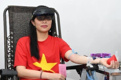 Chị Đoàn Thị Thanh Thủy trải nghiệm hiến máu khi đang đeo kính thực tế ảo tích hợp.