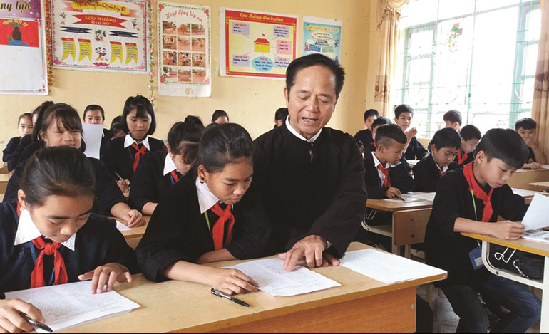 Nghệ nhân ưu tú Lâm Minh Sập dạy trẻ em trong xã hát dân ca Sán Chỉ. (Ảnh Nguyễn Hưởng) nghe-nhan-uu-tu-lam-minh-sap-day-tre-em-trong-xa-hat-dan-ca-san-chi-anh-nguyen-huong.jpg