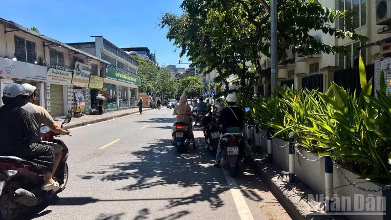 Người dân tận dụng những khoảng bóng râm ít ỏi để tránh nắng trong lúc chờ đèn đỏ. (Ảnh: YẾN PHƯƠNG)