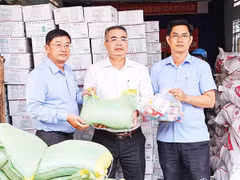 Nhà báo Lê Hoàng Triều (bên trái) trao quà hỗ trợ địa phương bị ảnh hưởng bởi mưa lũ.