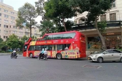 Xe buýt sử dụng ô-tô thoáng nóc chở khách du lịch tại trung tâm thành phố. (Ảnh: VÕ LÊ)