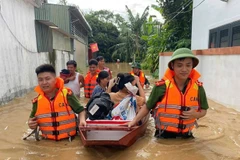 Công an xã Anh Sơn (Nghệ An) phối hợp lực lượng chức năng dùng thuyền hỗ trợ người dân khỏi các khu vực sạt lở, nguy cơ ngập cao. (Ảnh: ANH VŨ)