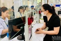 Cán bộ, công chức Thành phố Hồ Chí Minh giải quyết thủ tục hành chính cho người dân. (Ảnh: VƯƠNG LÊ)