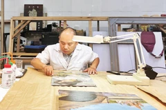 Ông Nguyễn Mạnh Hải làm sạch bức tranh của danh họa Trần Văn Cẩn.