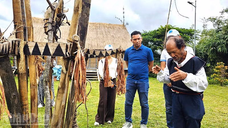 Già làng Đinh Văn Hmưnh kể câu chuyện Lễ hội đâm trâu của người Ba Na cho du khách nghe.