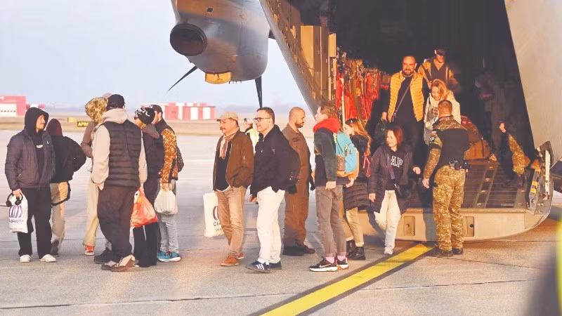 Người dân được sơ tán từ Trung Đông xuống máy bay quân sự khi đến Slovakia. (Ảnh TASR)