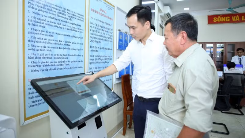 Hướng dẫn người dân thực hiện thủ tục hành chính tại Điểm phục vụ hành chính công xã Phúc Thịnh, thành phố Hà Nội. (Ảnh: NHẬT NAM)