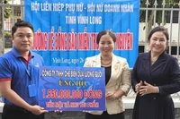 Công ty Trách nhiệm hữu hạn Chế biến dừa Lương Quới ủng hộ tiền mặt và nhu yếu phẩm trị giá hơn 1,5 tỷ đồng giúp đồng bào bị thiệt hại do mưa lũ. (Ảnh: HOÀNG TRUNG)