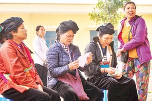 Phụ nữ dân tộc Dao ở xã Mường Chiềng (Đà Bắc) chia sẻ với nhau những dòng chữ trên toa thuốc-việc mà trước đây họ từng phải nhờ người khác làm giúp.